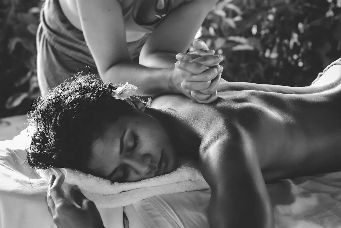 Massage therapist applying deep focused pressure during a sports massage session